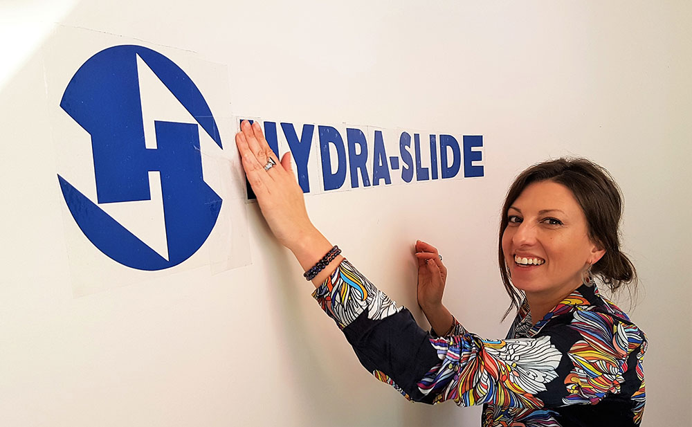 Janine Smith, vice president at Hydra-Slide, unveils the new logo.
