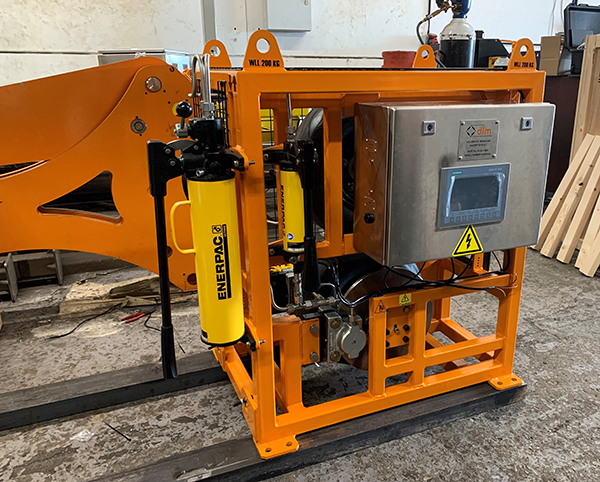 An Enerpac cylinder compresses the top and bottom wheels together.