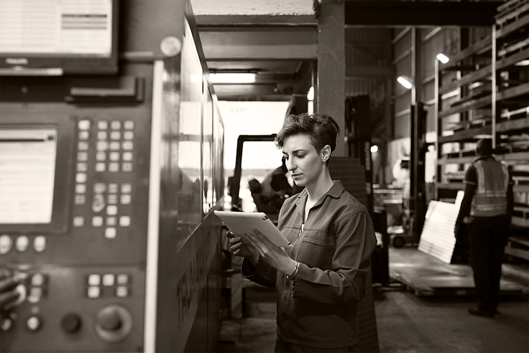 Employee looking at a tablet device in a warehouse work environment. Source: Image via Getty Images