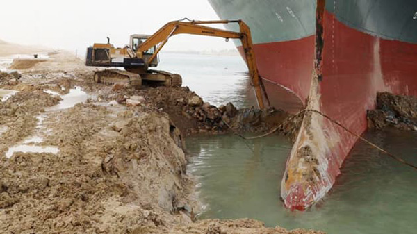 An excavator attempts to free Ever Given, one of the world’s largest container ships after it ran aground, Suez Canal, Egypt March 25, 2021. (Image Source: Reuters, Suez Canal Authority)