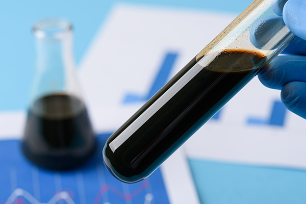 Crude oil in vial test tube in laboratory scientist hand. (Image by Shutterstock/nevodka.)