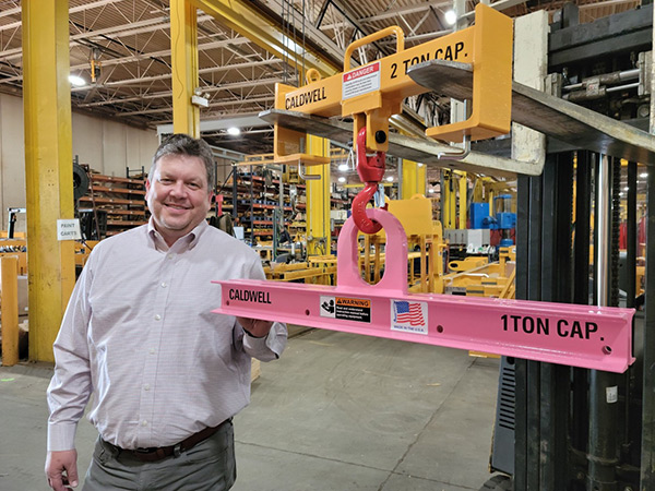 The concept was developed by Doug Stitt, president and CEO, The Caldwell Group, pictured with a pink Model 20 low headroom lifting beam.