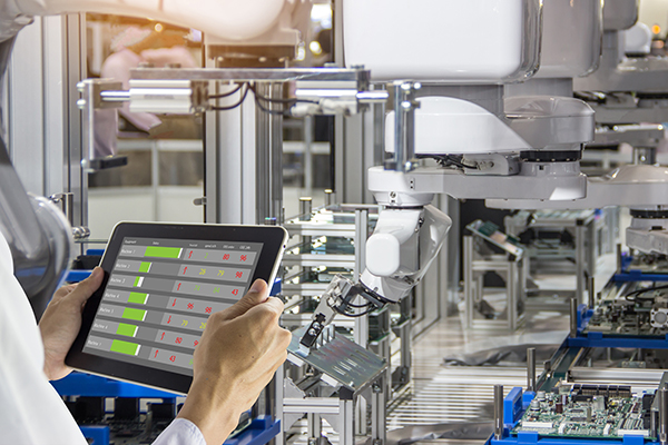 Engineers use a tablet for machine maintenance on the shop floor.