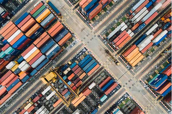 Aerial view of stacked shipping containers at a busy port, ready to embark on global journeys.
Source: Unsplash
