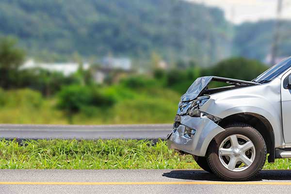 front side silver car damaged by accident on side of road