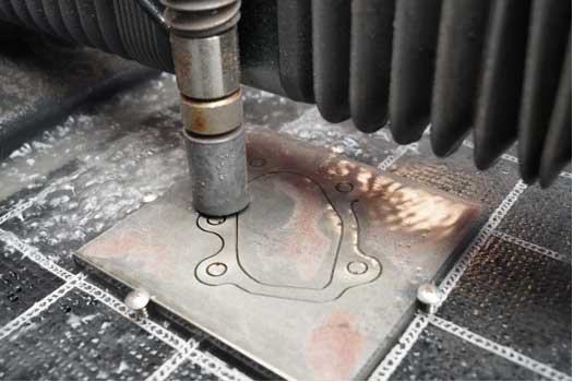 Compact waterjet cutter fabricating an aluminum flange for an automotive turbocharger installation.