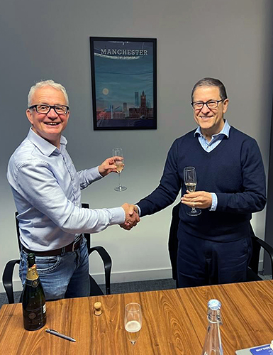 Neil Hyde of Cobra Machine (left) and John Tomaz of Wardwell (right) celebrate the signing of the deal.  Wardwell has acquired the assets of Cobra, its friendly competitor in braiding machinery.