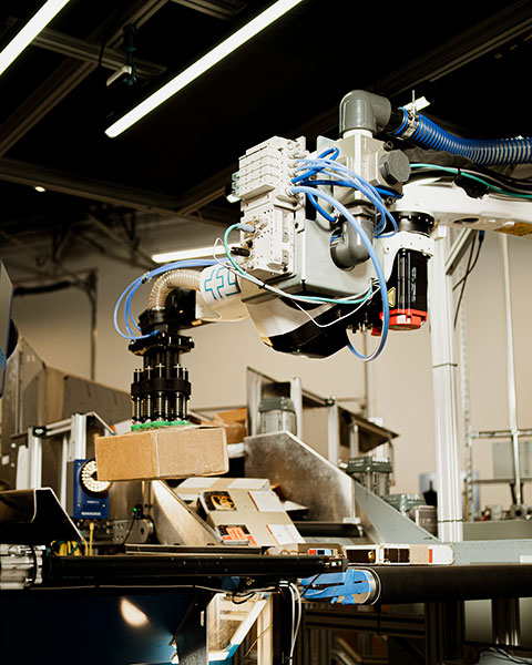 An induction robot transports a package, showcasing the efficiency and accuracy of modern robotic systems in streamlining logistics operations.