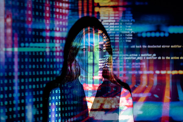 Computer code is projected over a woman’s face.
