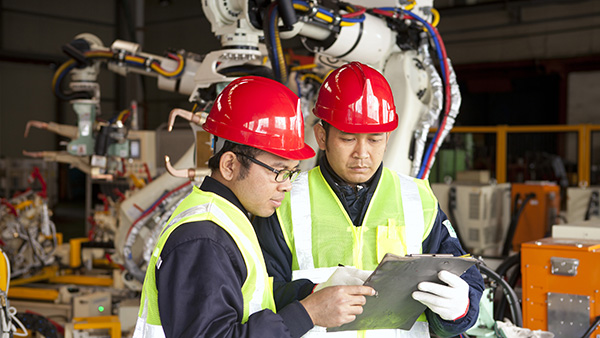 manufacturing workers monitoring equipment in facility